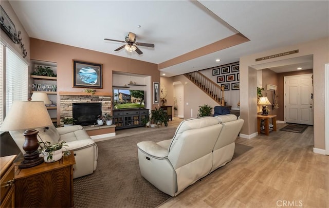 29207 Clear Spring Ln, Highland, CA 92346 - living area with ceiling fan, stairway, a stone fireplace, recessed lighting, and light wood-style floors