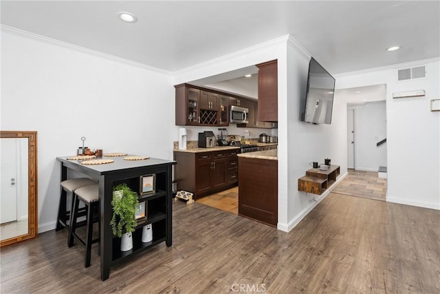 1675 W Lambert Rd Unit G, La Habra, CA 90631 - kitchen with stainless steel appliances, dark brown cabinets, wood finished floors, ornamental molding, and glass insert cabinets