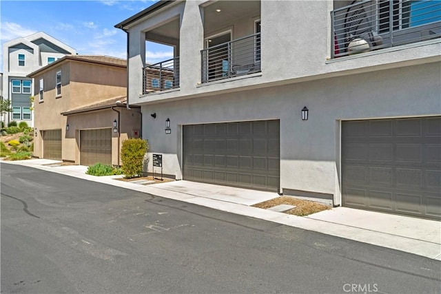 297 Lynx, Irvine, CA 92618 - view of front of house featuring an attached garage, stucco siding, and a balcony