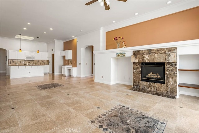 960 Hemingway Dr, Corona, CA 92878 - unfurnished living room with ornamental molding, ceiling fan, arched walkways, recessed lighting, and a premium fireplace