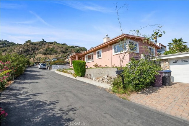 1606 Glenmont Dr, Glendale, CA 91207 - view of side of home with asphalt driveway, a chimney, and a garage