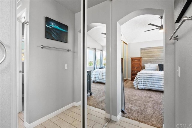655 Boysenberry Way, Oceanside, CA 92057 - corridor with baseboards, arched walkways, carpet floors, wood finished floors, and vaulted ceiling