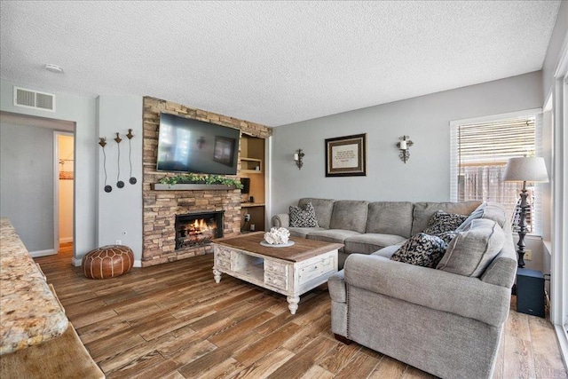655 Boysenberry Way, Oceanside, CA 92057 - living room featuring a textured ceiling, wood finished floors, and a stone fireplace