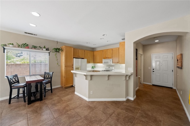 32839 Charmes Ct, Temecula, CA 92592 - kitchen featuring white appliances, arched walkways, a peninsula, light countertops, and recessed lighting