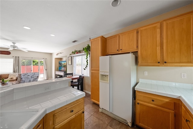 32839 Charmes Ct, Temecula, CA 92592 - kitchen with white refrigerator with ice dispenser, tile countertops, ceiling fan, light tile patterned floors, and recessed lighting