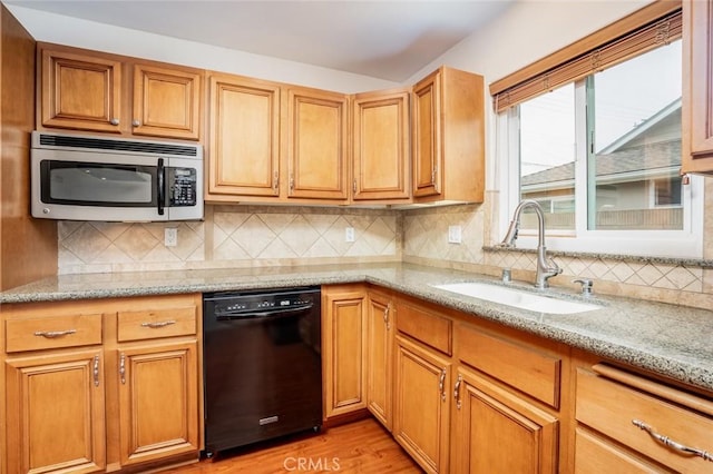 5202 Caliente Dr, Huntington Beach, CA 92649 - kitchen featuring black dishwasher, stainless steel microwave, a sink, light stone counters, and light wood finished floors
