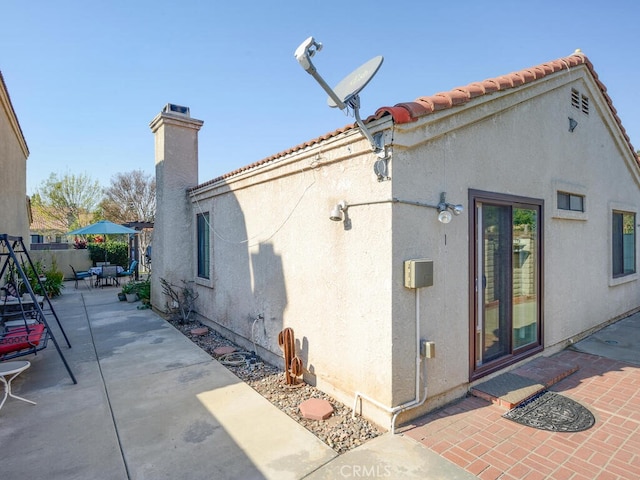 8619 San Miguel Pl, Rancho Cucamonga, CA 91730 - rear view of house featuring a patio area, a chimney, stucco siding, and a tile roof