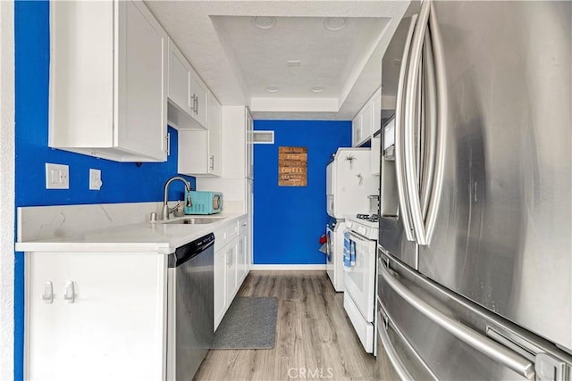 26422 Paseo Carmel Unit 20A, San Juan Capistrano, CA 92675 - kitchen with appliances with stainless steel finishes, a sink, light wood-style flooring, and white cabinetry