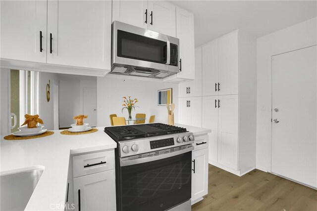 24855 Sundial Way, Moreno Valley, CA 92557 - kitchen featuring stainless steel appliances, light wood-style floors, light countertops, and white cabinetry