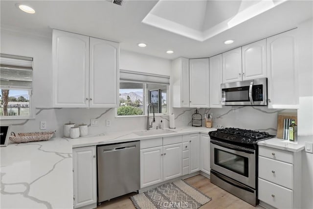 77355 Minnesota Ave, Palm Desert, CA 92211 - kitchen featuring stainless steel appliances, a sink, light stone counters, recessed lighting, and white cabinetry
