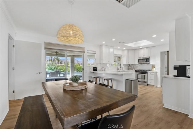 77355 Minnesota Ave, Palm Desert, CA 92211 - dining area featuring light wood finished floors, recessed lighting, and a skylight