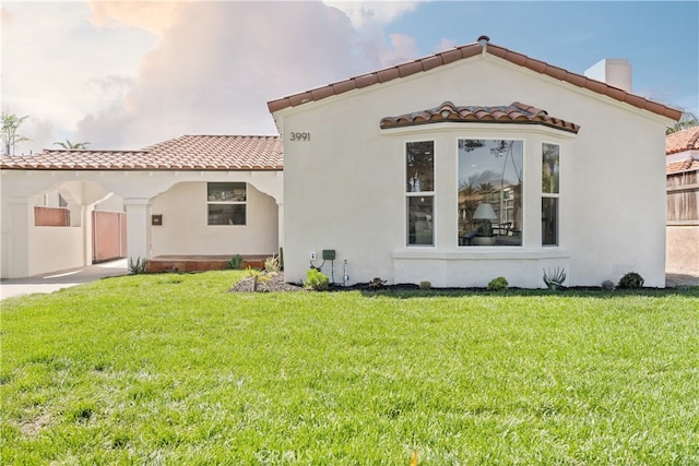 3991 Hubert Ave, Los Angeles, CA 90008 - back of house featuring a tile roof, a chimney, a yard, and stucco siding