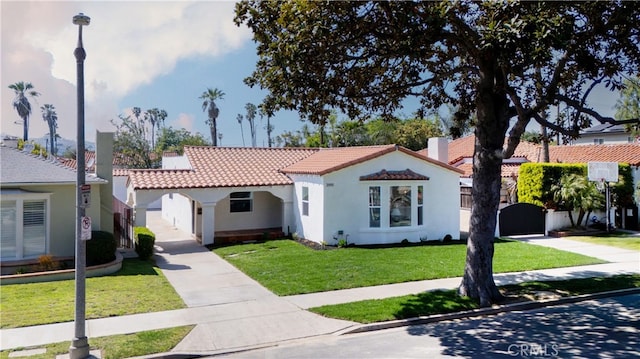 3991 Hubert Ave, Los Angeles, CA 90008 - mediterranean / spanish-style house with a tiled roof, stucco siding, a front yard, and driveway