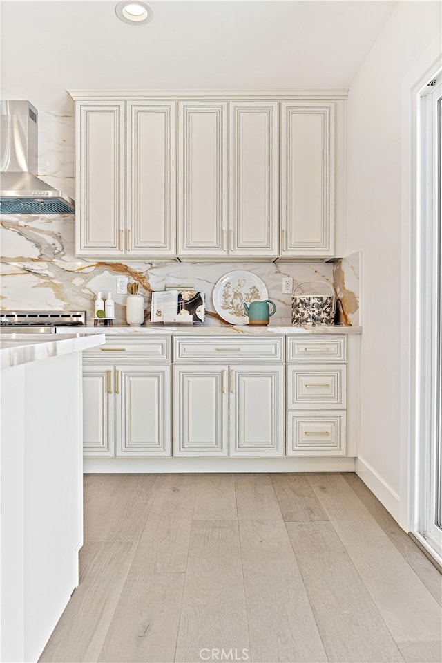 3991 Hubert Ave, Los Angeles, CA 90008 - kitchen featuring wall chimney exhaust hood, light countertops, decorative backsplash, light wood-style flooring, and recessed lighting