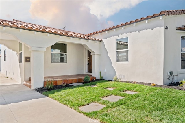 3991 Hubert Ave, Los Angeles, CA 90008 - view of front of house with stucco siding, a front lawn, a tiled roof, and a porch