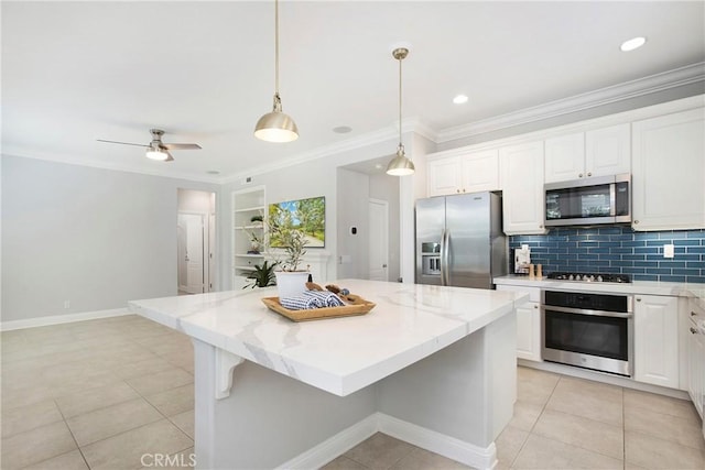 25 Bellflower St, Ladera Ranch, CA 92694 - kitchen featuring appliances with stainless steel finishes, a kitchen island, white cabinetry, decorative backsplash, and light stone counters