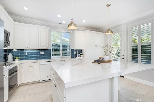 25 Bellflower St, Ladera Ranch, CA 92694 - kitchen featuring appliances with stainless steel finishes, crown molding, light tile patterned floors, decorative backsplash, and healthy amount of natural light