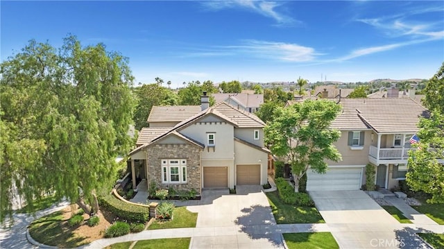 25 Bellflower St, Ladera Ranch, CA 92694 - view of front of property featuring driveway, stone siding, stucco siding, a chimney, and a tile roof