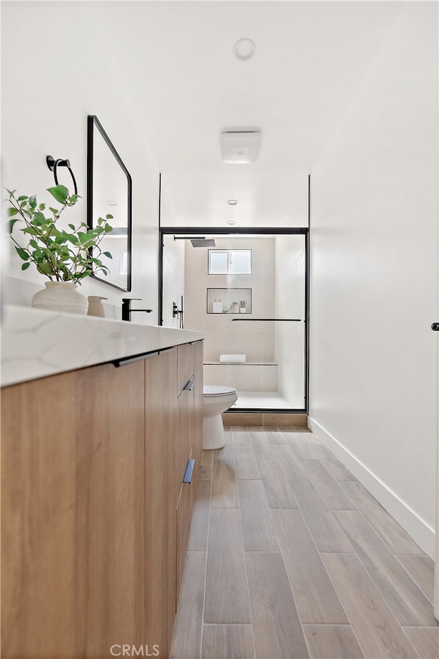 3927 Welland Ave, Los Angeles, CA 90008 - bathroom with vanity, toilet, wood finished floors, a shower, and baseboards