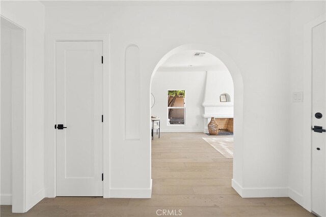 3927 Welland Ave, Los Angeles, CA 90008 - hallway with arched walkways, light wood-style floors, and baseboards