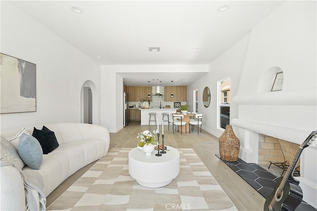 3927 Welland Ave, Los Angeles, CA 90008 - living room with arched walkways, light wood-type flooring, recessed lighting, and baseboards