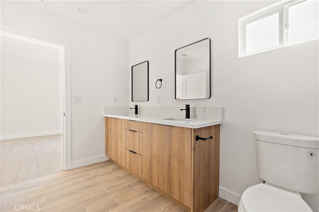 3927 Welland Ave, Los Angeles, CA 90008 - bathroom featuring baseboards, wood finished floors, toilet, and double vanity