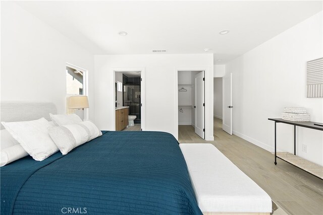 3927 Welland Ave, Los Angeles, CA 90008 - bedroom with light wood finished floors, a spacious closet, baseboards, connected bathroom, and recessed lighting