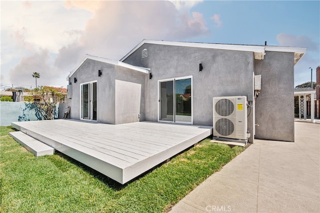 3927 Welland Ave, Los Angeles, CA 90008 - rear view of house with a cooling unit, a wooden deck, stucco siding, and a lawn