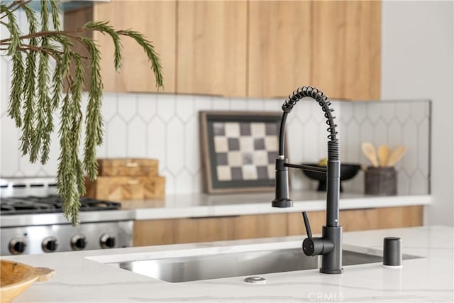 3927 Welland Ave, Los Angeles, CA 90008 - kitchen view of a sink, tasteful backsplash, range, and light stone countertops