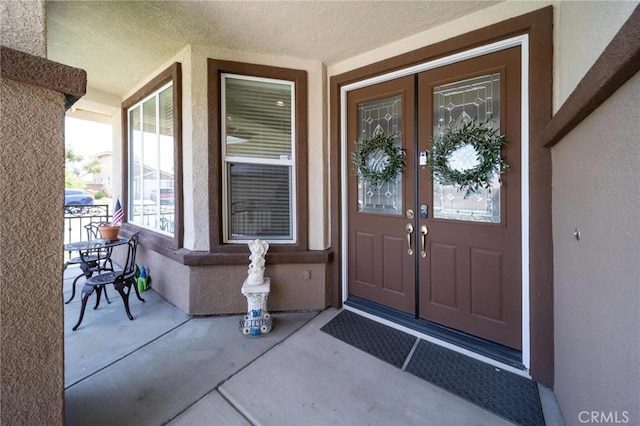 29183 Paperflower Ln, Menifee, CA 92584 - doorway to property featuring french doors, stucco siding, and covered porch