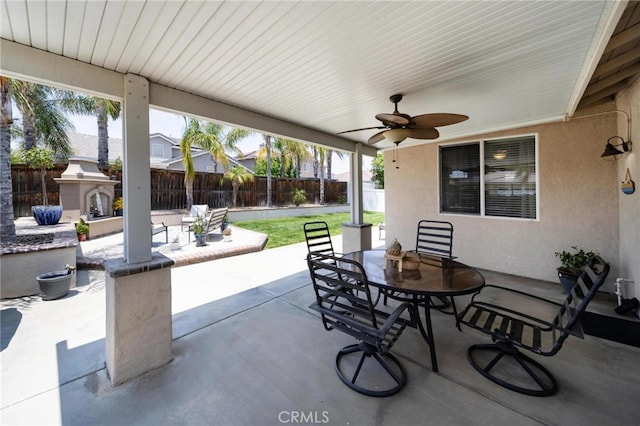 29183 Paperflower Ln, Menifee, CA 92584 - fenced backyard with outdoor dining area, an outdoor fireplace, a patio area, and ceiling fan