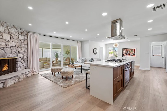 2116 E Thackery St, West Covina, CA 91791 - kitchen featuring island range hood, appliances with stainless steel finishes, open floor plan, a kitchen island, and light countertops