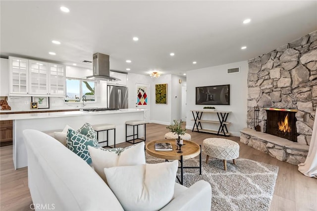 2116 E Thackery St, West Covina, CA 91791 - living room featuring light wood-style floors, recessed lighting, and a stone fireplace