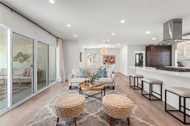 2116 E Thackery St, West Covina, CA 91791 - living area featuring stacked washer and clothes dryer, light wood-type flooring, recessed lighting, and a chandelier