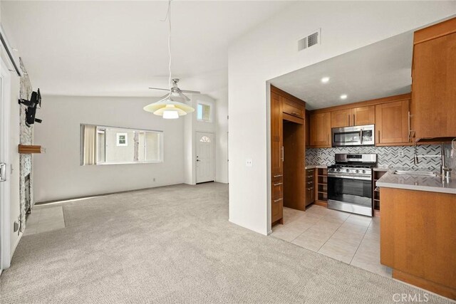 549 Springbrook N, Irvine, CA 92614 - kitchen featuring stainless steel appliances, brown cabinetry, a ceiling fan, light carpet, and tasteful backsplash