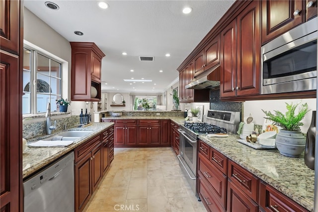 77 Seton Rd, Irvine, CA 92612 - kitchen featuring stainless steel appliances, reddish brown cabinets, under cabinet range hood, recessed lighting, and light stone counters