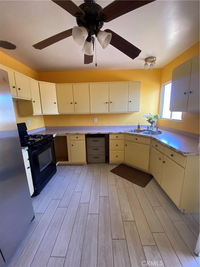 1134 E Highland Ct, Ontario, CA 91764 - kitchen with black gas range, a sink, light wood finished floors, light countertops, and ceiling fan