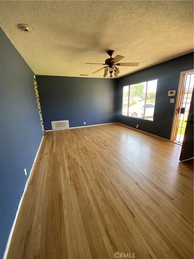 1134 E Highland Ct, Ontario, CA 91764 - empty room featuring a textured ceiling, wood finished floors, a ceiling fan, and plenty of natural light