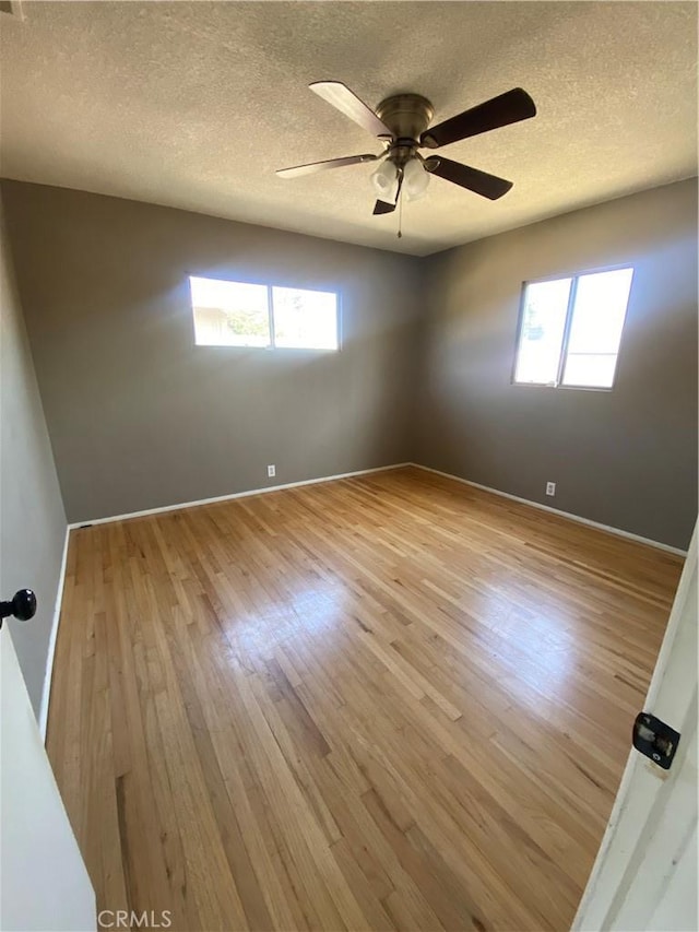1134 E Highland Ct, Ontario, CA 91764 - spare room featuring plenty of natural light, a textured ceiling, light wood-type flooring, a ceiling fan, and baseboards