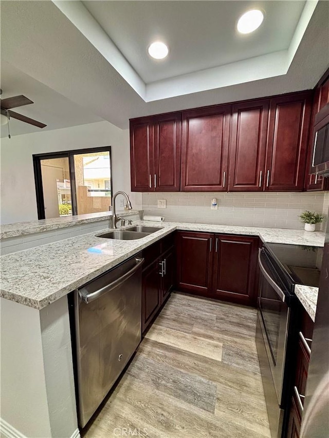 113 Pearl Unit 106, Laguna Niguel, CA 92677 - kitchen with a sink, reddish brown cabinets, appliances with stainless steel finishes, a peninsula, and a tray ceiling