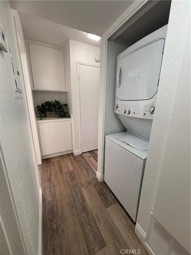 113 Pearl Unit 106, Laguna Niguel, CA 92677 - laundry room with stacked washer and clothes dryer, wood finished floors, baseboards, and a textured wall