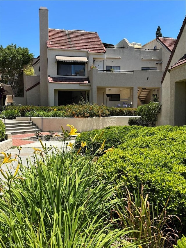 113 Pearl Unit 106, Laguna Niguel, CA 92677 - back of property with a tiled roof, stucco siding, a chimney, and stairs