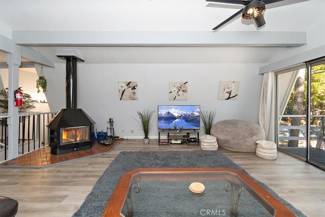 598 Dahlia Dr, Green Valley Lake, CA 92341 - living room with wood finished floors, a wood stove, ceiling fan, and beamed ceiling