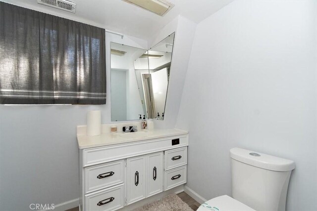 598 Dahlia Dr, Green Valley Lake, CA 92341 - half bathroom with toilet, vanity, baseboards, and wood finished floors
