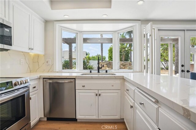 25585 Chrisanta Dr, Mission Viejo, CA 92691 - kitchen with stainless steel appliances, a sink, white cabinets, decorative backsplash, and recessed lighting