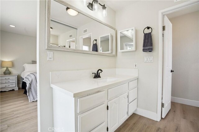 25585 Chrisanta Dr, Mission Viejo, CA 92691 - bathroom featuring vanity, wood finished floors, baseboards, and connected bathroom