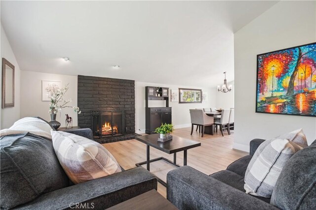 25585 Chrisanta Dr, Mission Viejo, CA 92691 - living room with light wood-type flooring, a brick fireplace, a chandelier, and baseboards