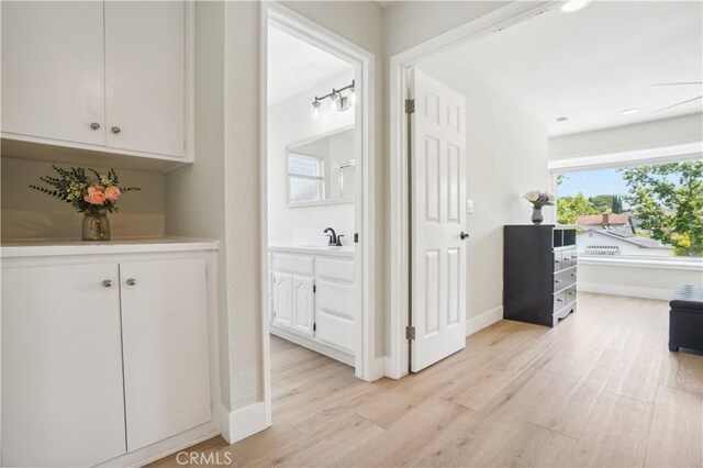 25585 Chrisanta Dr, Mission Viejo, CA 92691 - corridor with light wood-style floors, a sink, and baseboards