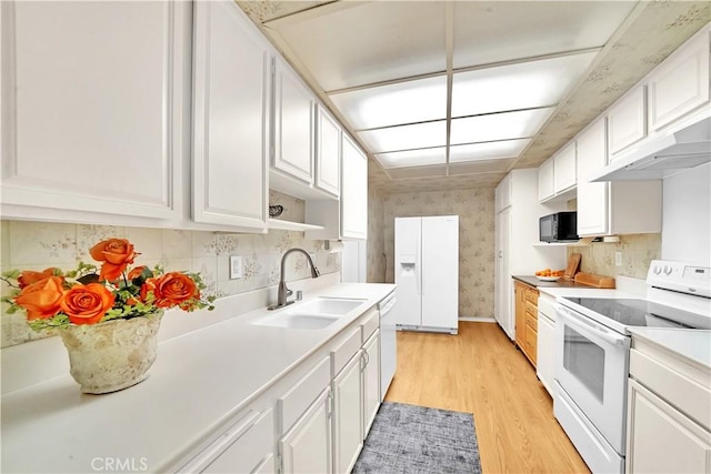 5509 Paseo Del Lago W Unit C, Laguna Woods, CA 92637 - kitchen featuring white appliances, a sink, under cabinet range hood, light wood-style flooring, and light countertops