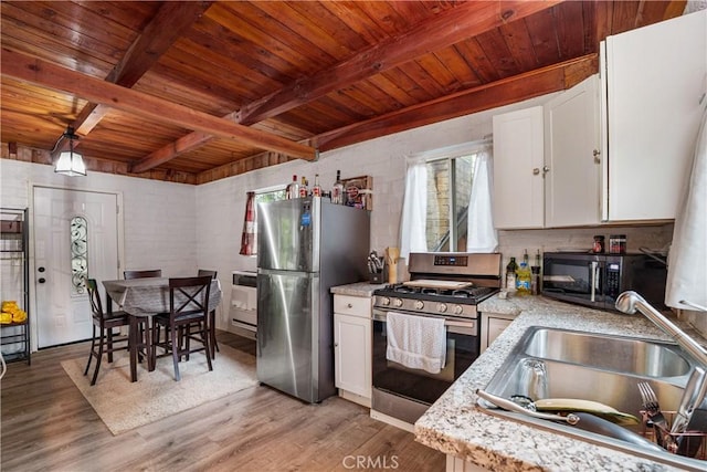423 Forest Ln, Crestline, CA 92325 - kitchen with stainless steel appliances, wooden ceiling with exposed beams, white cabinets, light wood-type flooring, and light stone counters